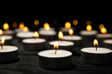 Obraz na płótnie Canvas Group of burning candles on black background, close up