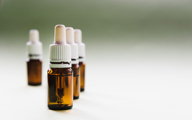 cosmetology, skin care, a row of glass bottles with pipettes and hyaluronic acid inside on a light...
