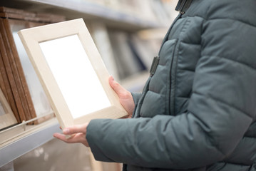 Buyer choosing a new photo frame in a store.