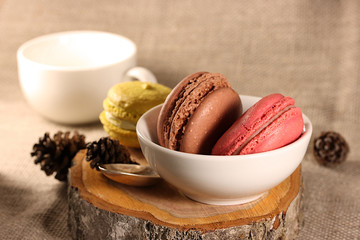 Brown, red and yellow cookies on a wooden stand on a white cup background