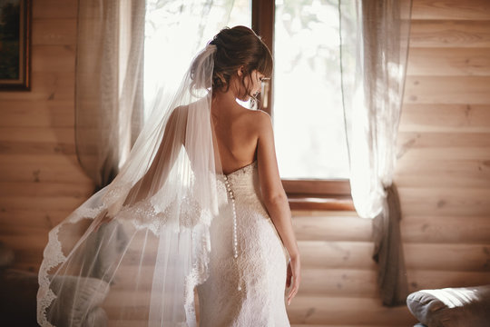 beautiful bride in a dress turned her back on the camera. Beautiful bride with fashion veil. Tender bride in wedding dress.