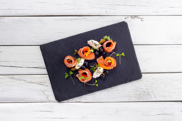 salmon with cheese and olives on a white wooden background