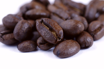 A group of freshly roasted coffee beans on a white background.Close-up, horizontal, macro, place for text.