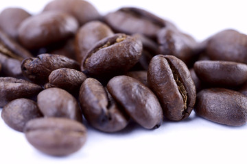 A group of freshly roasted coffee beans on a white background.Close-up, horizontal, macro, place for text.