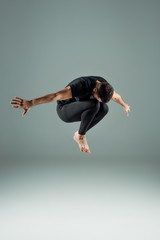 Fototapeta na wymiar dancer in black leggings and t-shirt dancing contemporary on dark background