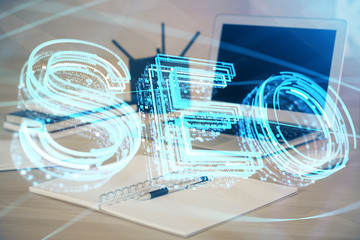 Multi exposure of table with computer and seo drawing hologram. Search optimization concept.