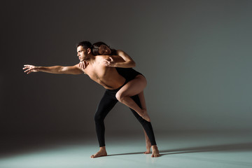 sexy dancers dancing contemporary on dark background with copy space