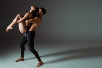 Obraz premium sexy dancers dancing contemporary on dark background with copy space