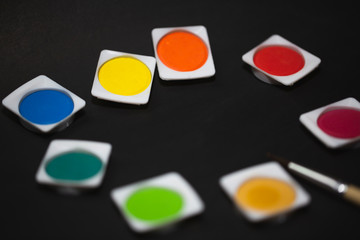 Painting tools including brushes, watercolor on nice gentle dark gray and textured background.