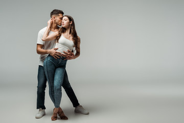 dancers with closed eyes dancing bachata on grey background