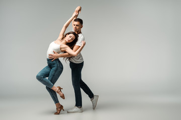 dancers with closed eyes dancing bachata on grey background