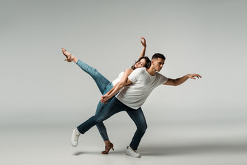 dancers with closed eyes dancing bachata on grey background