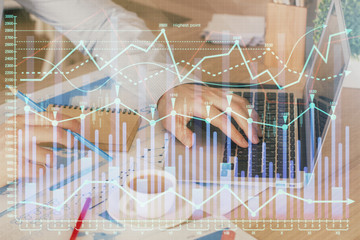 Forex graph with businessman working on computer in office on background. Concept of hardworking....