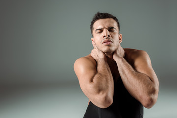 Obraz premium handsome dancer with closed eyes dancing contemporary on grey background