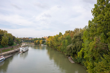 Fototapeta na wymiar View of the green rive Tiber in Rome looking from the bridge