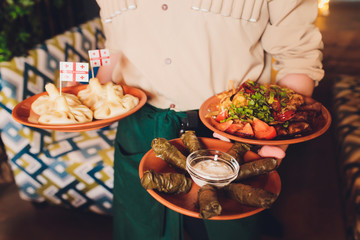 View from above of georgian cuisine on brown wooden table.Traditional georgian food-khinkali,kharcho,chahokhbili,phali,lobio and local sauces - tkemali, satsebeli, adzhika.Top view.Copy space for text