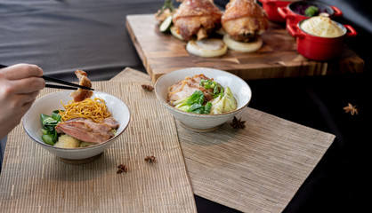 A man holding crispy pork leg noodle with chopsticks placed on Japanese mat, Selective focus, copy space