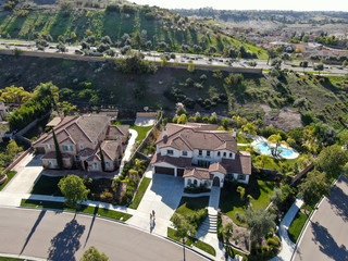 Fototapeta premium Aerial view of neighborhood with residential modern subdivision luxury houses and small road during sunny day in Chula Vista, California, USA.