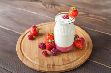Homemade yogurt in a jar close-up. Fermented milk product with strawberries and copy space.