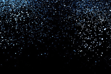 Splash of blue sparkles on black background. - 310490419
