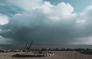 Large anchor on Salthill promenade with Galway bay and rain clouds in the background. Taken in...