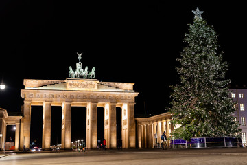 Fototapeta premium Brandenburg Gate with a Christmas tree and tourists at night, Christmas time, Christmas lights, Berlin Germany