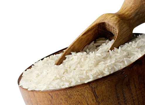 Uncooked long rice basmati in wooden bowl with scoop isolated on white.