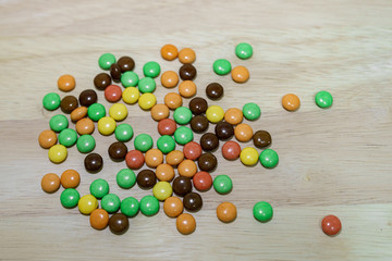 Many colorful candies on a wooden background