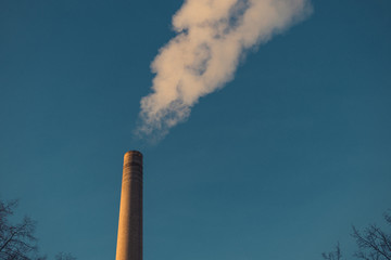 Image of industrial chimney and smoke with blue sky