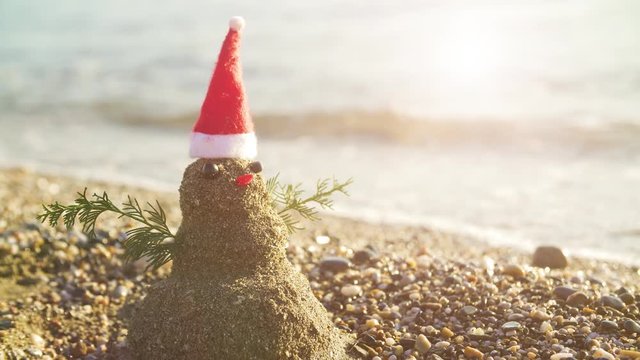 Snowman on holidays made of sand instead of snow. Concept tropical   resort could be used for New Year and Christmas