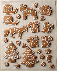 Homemade Christmas gingerbread cookies in the form of animals on parchment paper