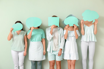 Naklejka premium People with blank speech bubbles on color background