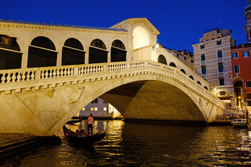 Obraz na płótnie Canvas Grand Canal and Rialto bridge, Venice, Italy. Beautiful romantic city lights in Italy. Beautiful view of traditional gondola on famous Rialto Bridge at night. Vacation in Italian city on water. 