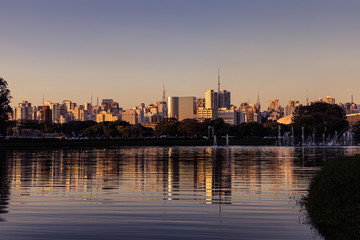 Fototapeta na wymiar Fim de tarde em São Paulo, com reflexo em lago ao entardecer.