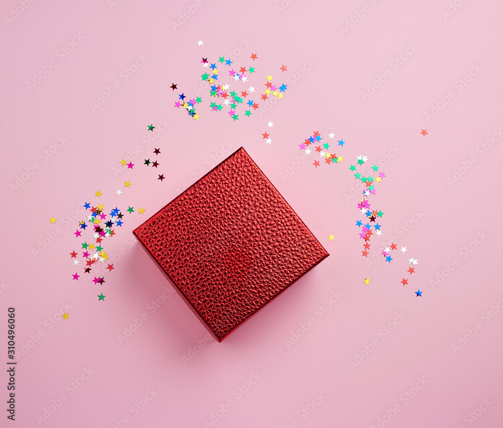 Poster square red shiny box and multicolored sparkles on a pink background