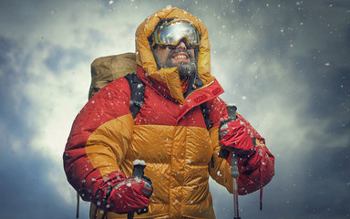 Climber reaching the summit. Snow storm.