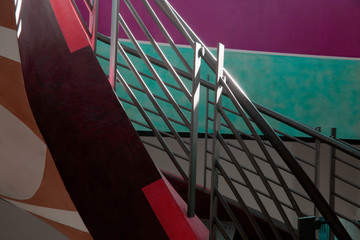 Colorized photo of staircase with shiny metal balustrade. Multicolor abstract background on the subject of modern architecture, business or construction industry.