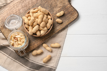Tasty peanuts on white wooden background