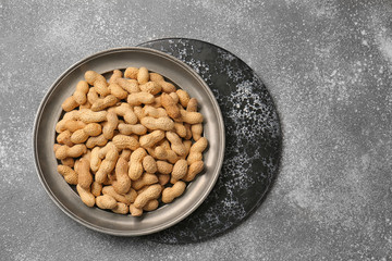 Tray with peanuts on grey background