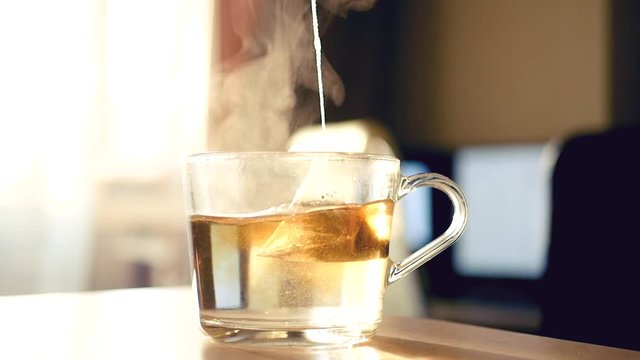 Brew black tea in a bag in a transparent cup. HD, 1920x1080, slow motion