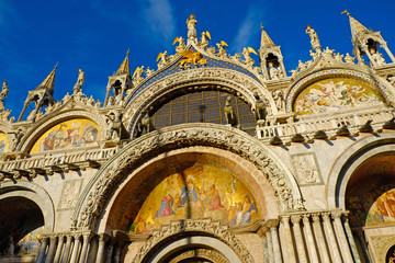 Obraz premium Basilica di San Marco under blue sky, Venice, Italy. Saint Mark Basilica and Doge's Palace. Cathedral of San Marco. Roof architecture details with lion, symbol of the City of Venice. 