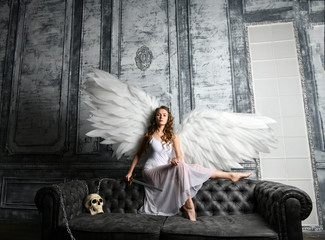 white angel with a sword of fair retribution and a crystal ball on a gray background