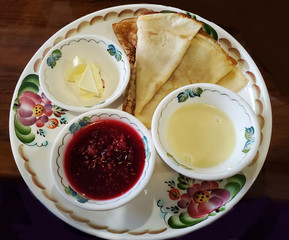 beautiful plate with pancakes, jam, butter on a wooden table. Traditional Russian cuisine, breakfast