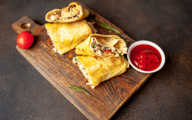 Mexican burrito wraps with chicken and vegetables on a cutting board, on a background of concrete, mexican shawarma