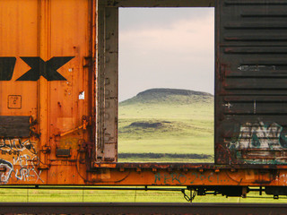 Railroad boxcar with opened door and early morning vista in the background