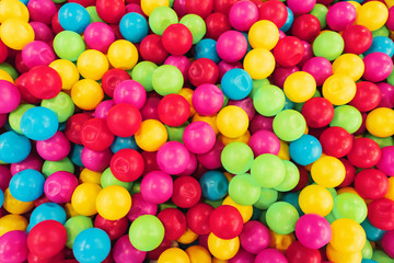 Fototapeta na wymiar texture on the wallpaper a lot of colorful balls in a heap, a children's pool for games of preschool age, bright colors, spherical shape, cause emotion joy, background, material plastic.