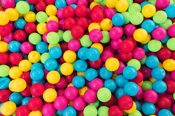 Fototapeta na wymiar texture on the wallpaper a lot of colorful balls in a heap, a children's pool for games of preschool age, bright colors, spherical shape, cause emotion joy, background, material plastic.