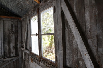 Fototapeta na wymiar abandoned wooden old cabin with garden view window