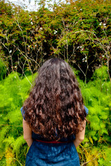 Woman from behind with long hair standing in backyard