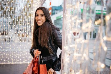 Woman entering at outside cafe with shopping bags